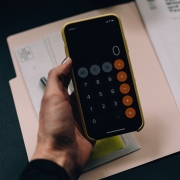 holding iphone calculator over documents